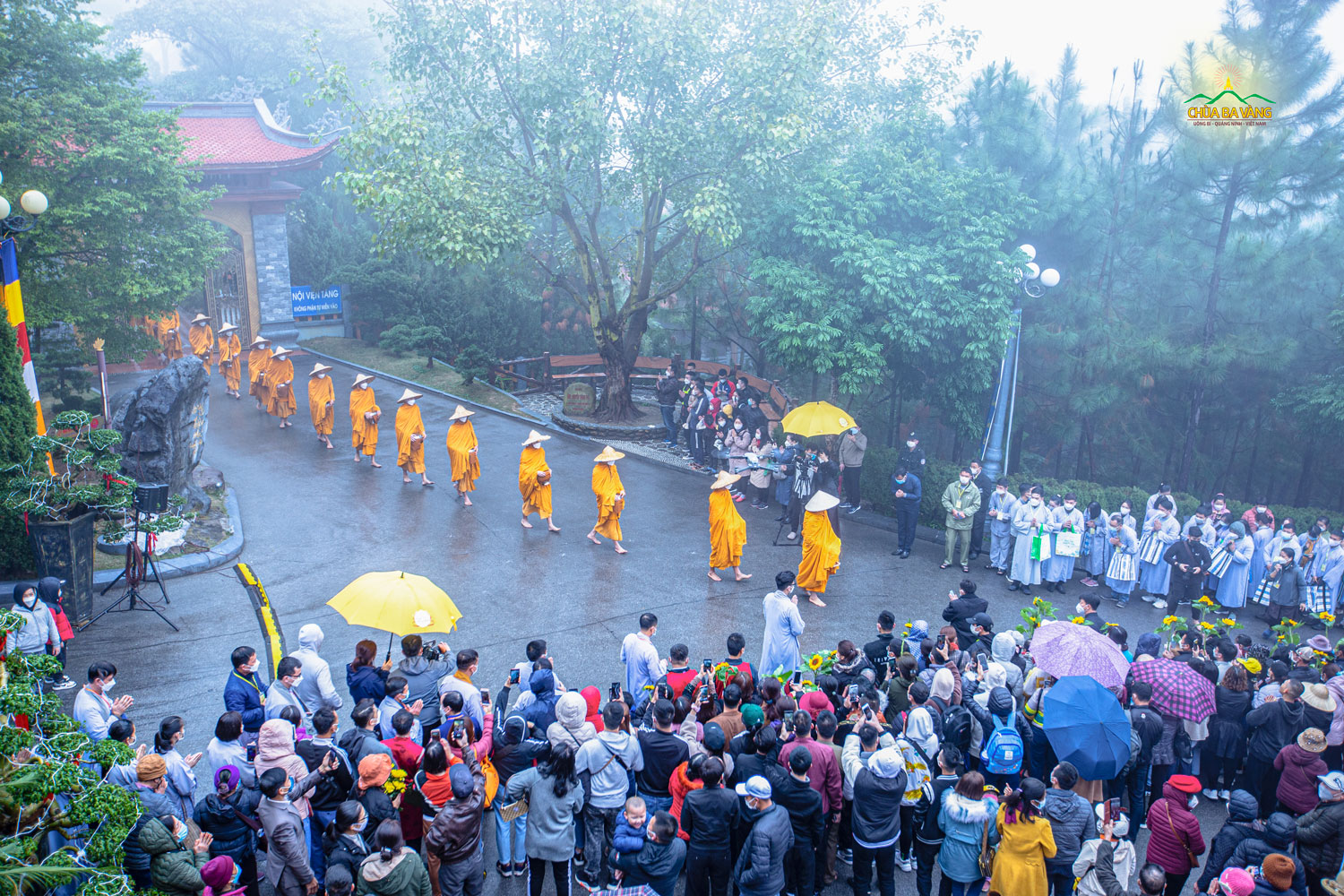 Hình ảnh Tăng đoàn chùa Ba Vàng đội nón, đeo bình bát đi khất thực trong tiết trời mưa xuân