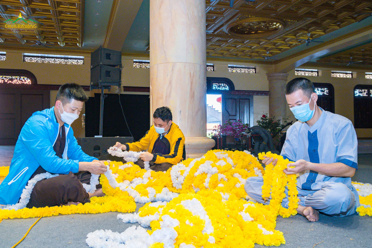 Các Phật tử kết hoa trang trí chuẩn bị cho việc trang trí sân khấu biểu diễn