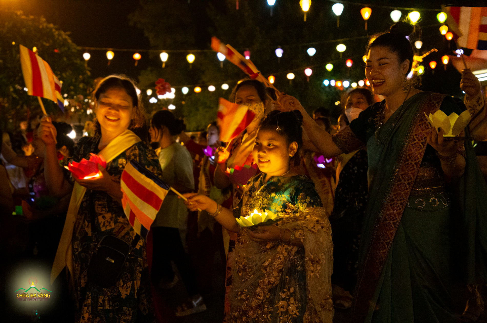 Trong trang phục truyền thống của Ấn Độ, bạn nhỏ háo hức phất cao lá cờ Phật đản, cầm hoa đăng diễu hành 