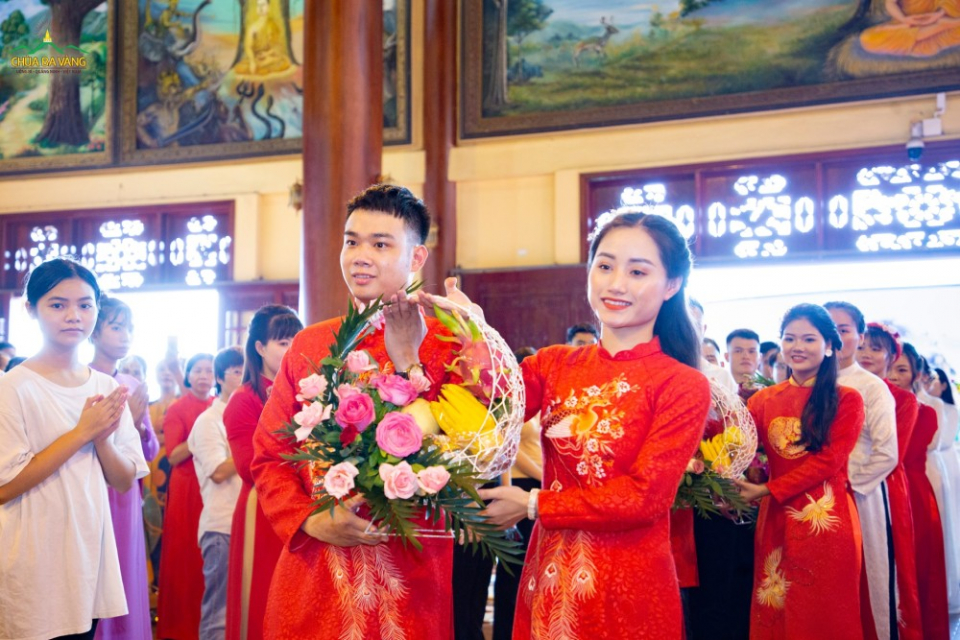 Các cặp đôi trong trang phục truyền thống của dân tộc cùng dâng hoa cúng Phật.
