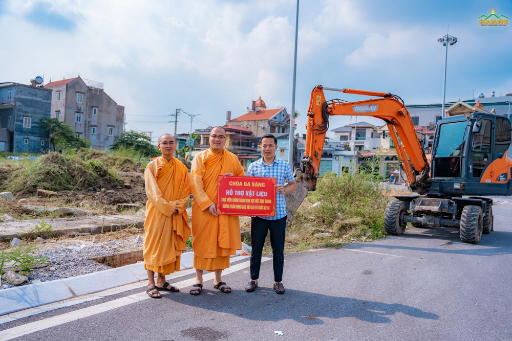 Đại diện chư Tăng chùa Ba Vàng trao biển hỗ trợ vật liệu thực hiện chỉnh trang khu vực nút giao thông đường Trần Hưng Đạo kéo dài và quốc lộ 18.