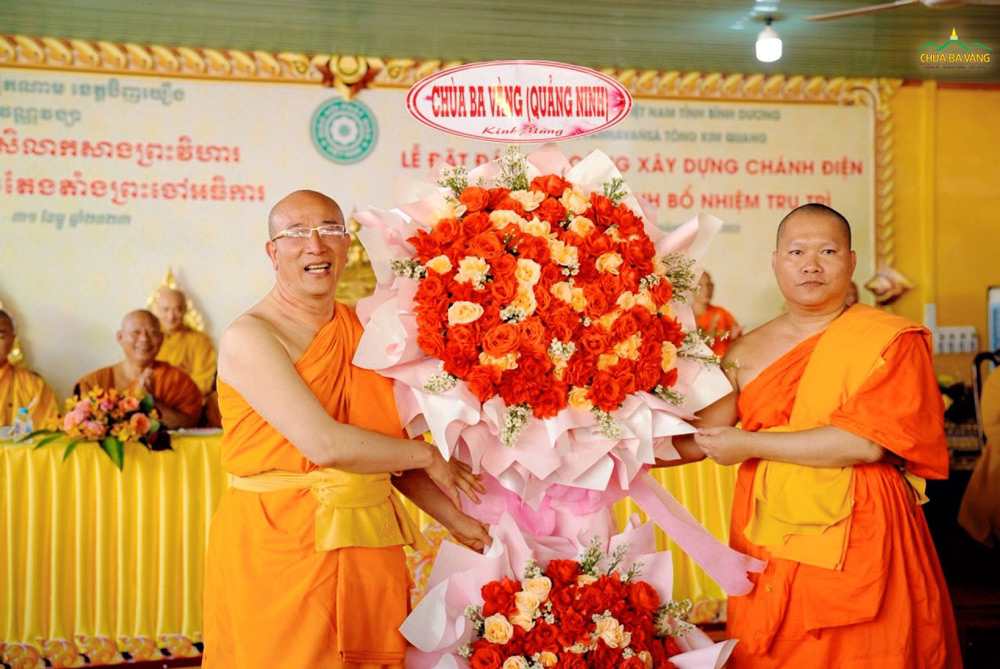 Thầy Thích Trúc Thái Minh trao lẵng hoa chúc mừng của chùa Ba Vàng trong buổi lễ