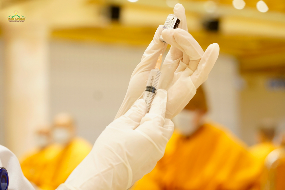 Nhân viên y tế tiến hành lấy mẫu vaccine để tiêm phòng COVID - 19