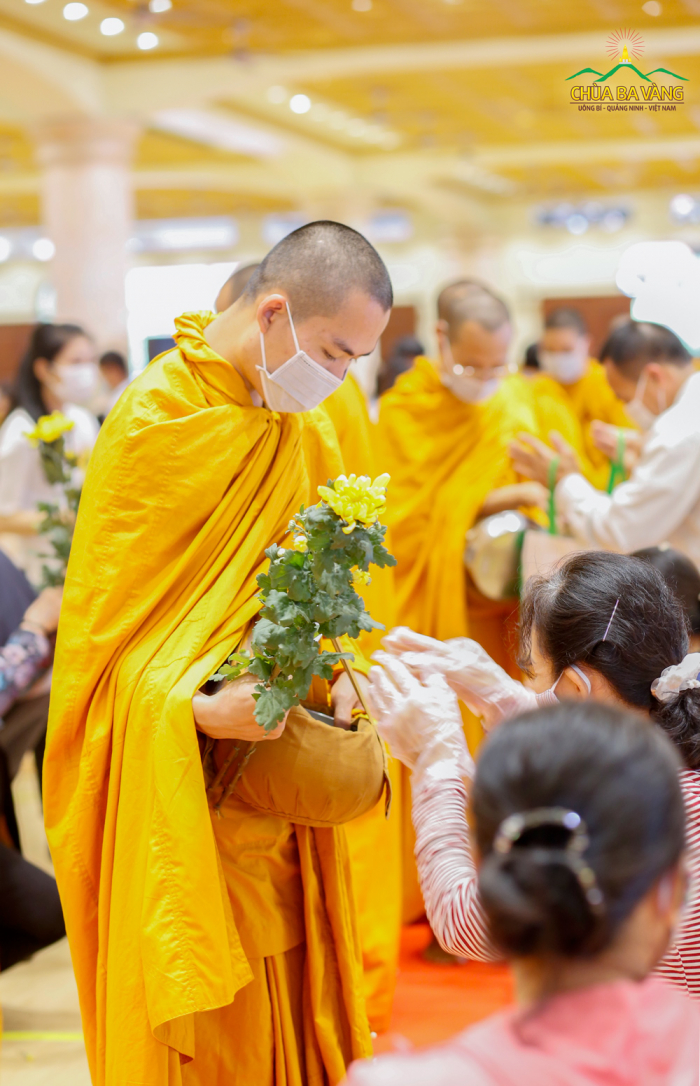 Các Phật tử trong CLB Cúc Vàng dâng những đóa hoa và phẩm vật cúng dường chư Tăng chùa Ba Vàng